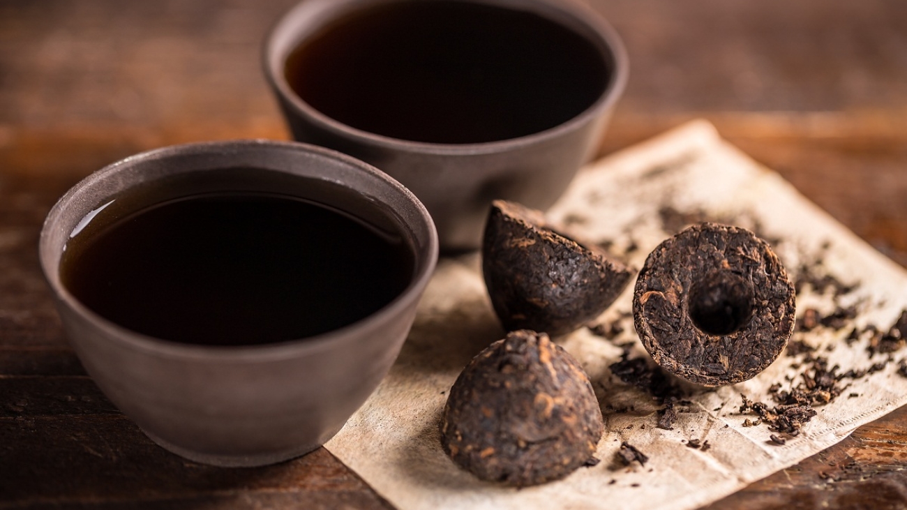 Cups of black tea with pressed tea leaves