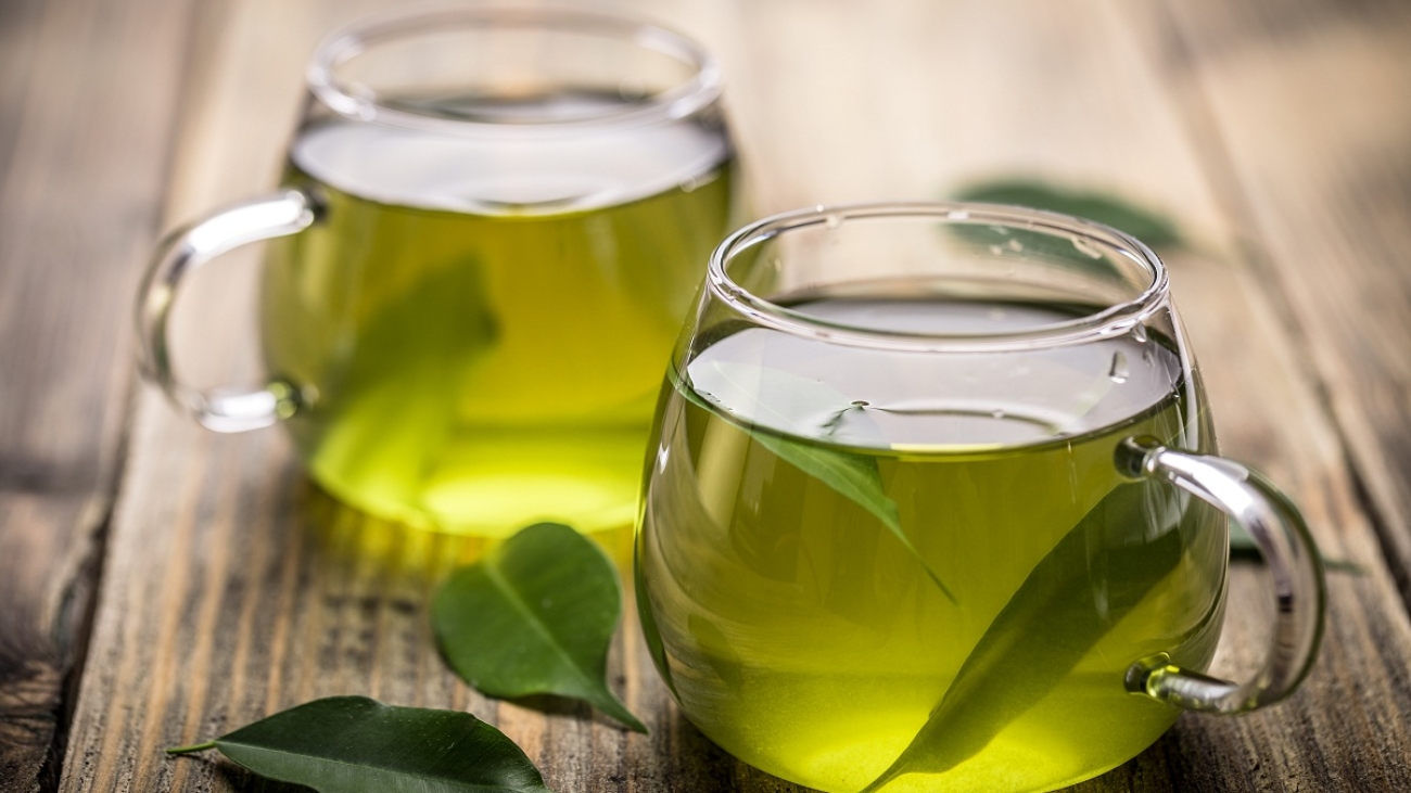 Fresh green tea with tea leaves in the water